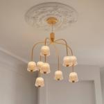 Nuura LED luster Asteea 9, Ø 66 cm, mosadzová farba/číra